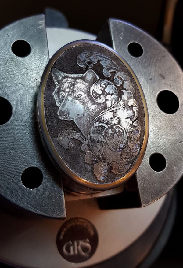 Griffkappe mit graviertem Hund und Ornament, in einer Gravierkugel eingespannt