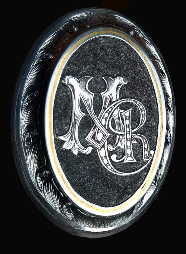 Griffkappe mit Monogramm in goldenem Rahmen