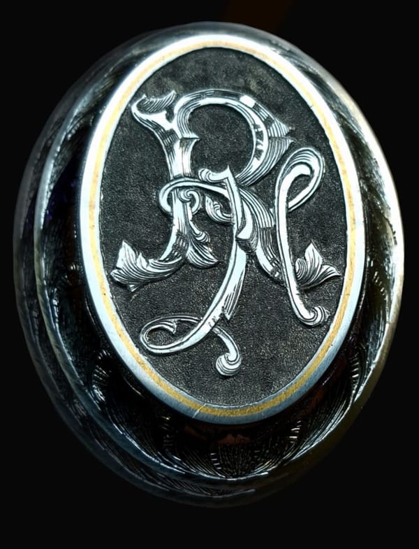 Griffkappe mit Ziermonogramm in goldenem Rahmen