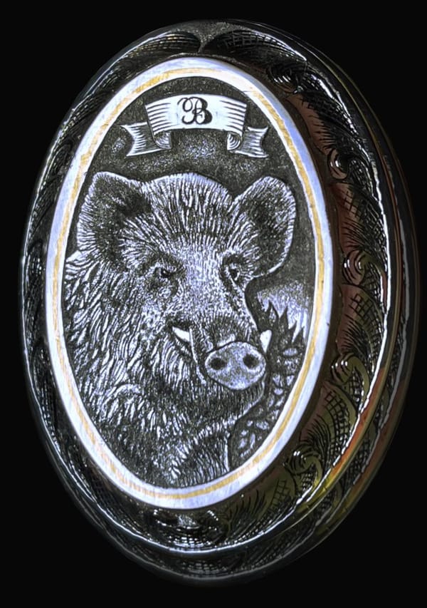 Griffkappe mit graviertem Wildschweinkopf und Initiale auf einem Band
