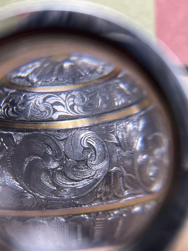 Finished engraved bolt knob seen through a magnifying glass