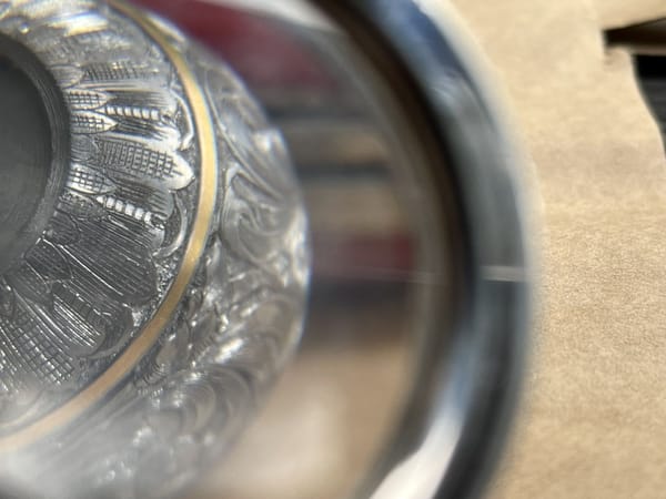 Close-up of an engraved bolt knob through a magnifying glass