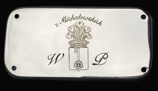 Grawerowana tabliczka z herbem, napisem v. Michałowskich i inicjałami