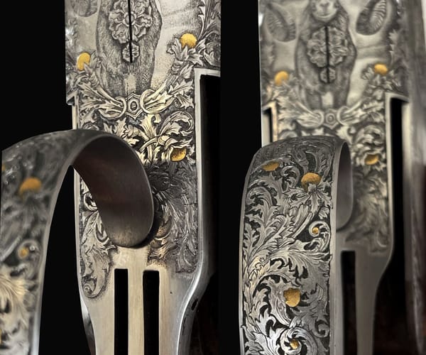 Nahaufnahme eines gravierten Abzugsbügels mit Ornament und Goldeinlagen