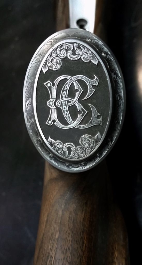 Griffkappe mit graviertem Monogramm am Schaft einer Repetierbüchse